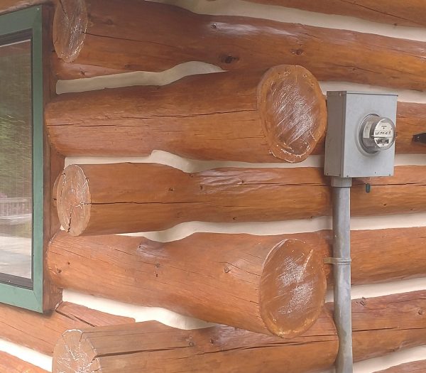 Log ends on a log home stained and chinked by wildwood log home restoration.
